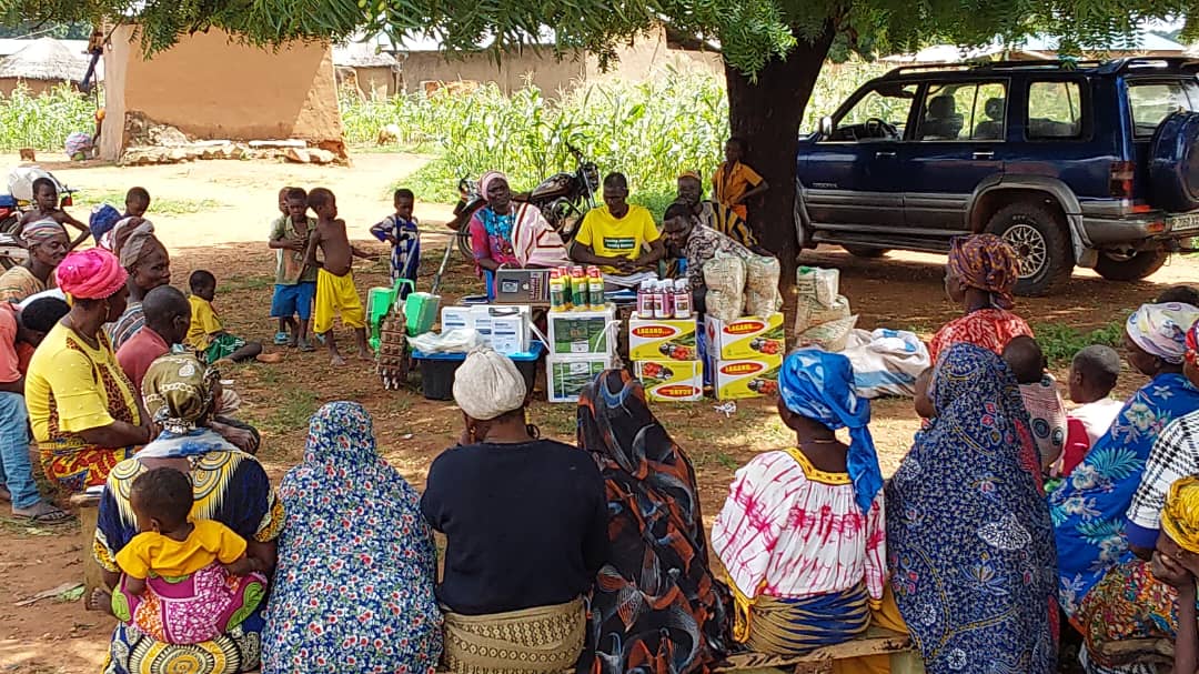 DAJRIM community gathering with products displayed under a tree